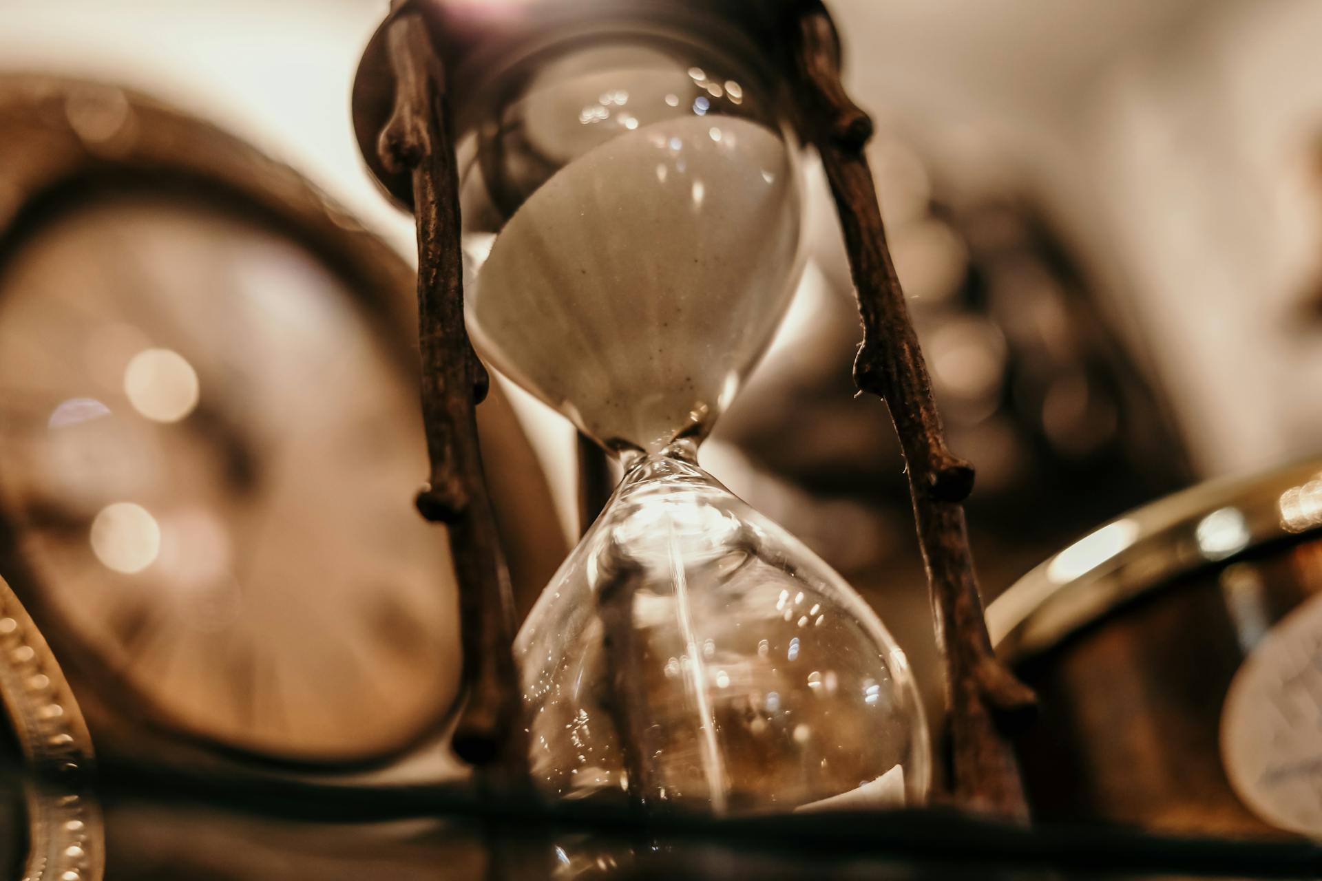Sanduhr vor unscharfer Uhr im Hintergrund – Symbolbild für Verjährung und Beginn der Festsetzungsfrist im Schenkungsteuerrecht